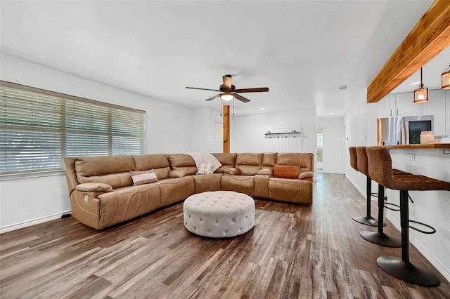 living room with plenty of natural light, baseboards, and wood finished floors