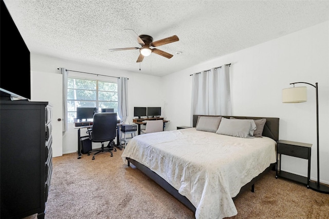 carpeted bedroom featuring ceiling fan and a textured ceiling