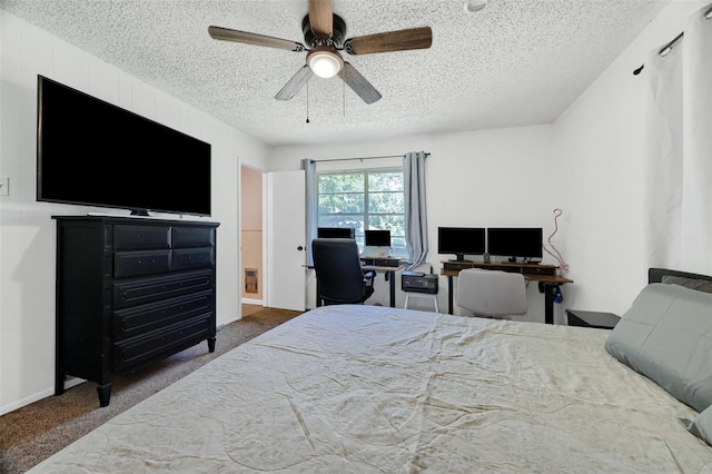 bedroom with a ceiling fan, baseboards, dark carpet, and a textured ceiling