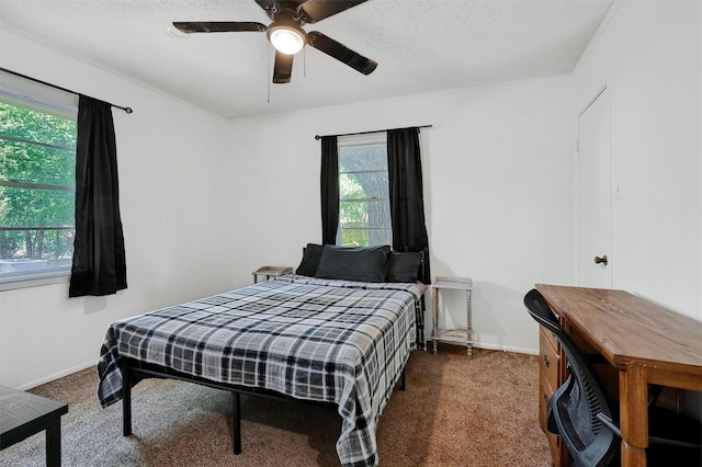 bedroom with a ceiling fan, baseboards, dark colored carpet, and a textured ceiling