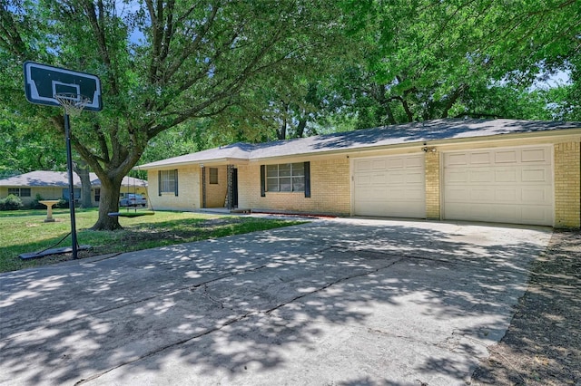 single story home featuring a garage, concrete driveway, and brick siding