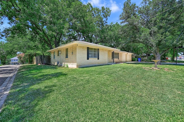 view of home's exterior featuring a yard, fence, and brick siding