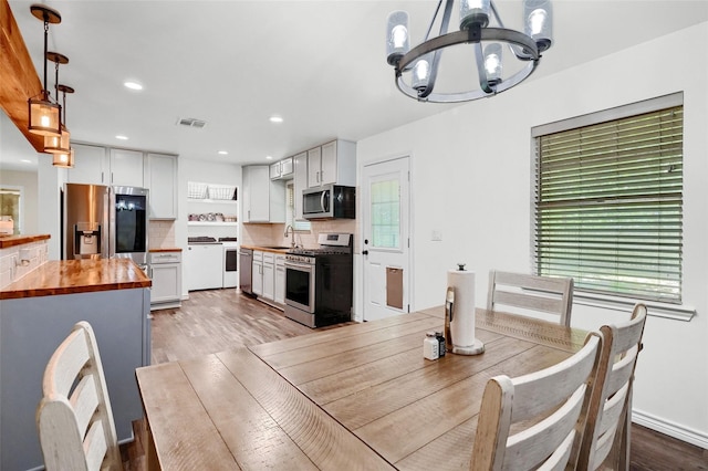 dining room featuring light wood-type flooring, visible vents, a chandelier, and recessed lighting