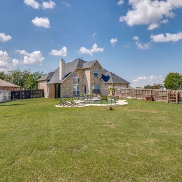 rear view of property with a patio area, a fenced backyard, and a yard