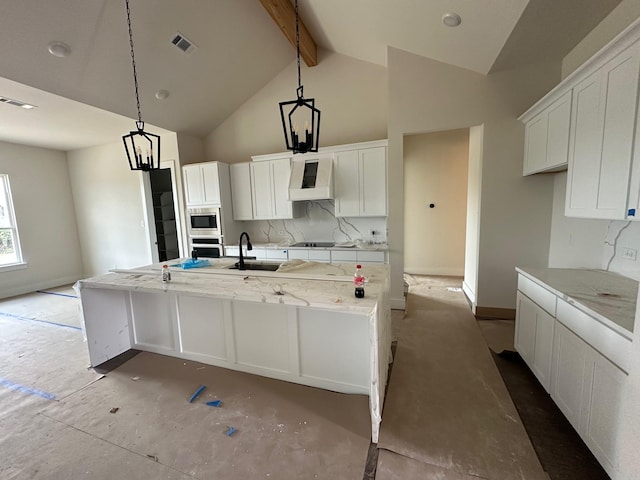 1045 Woodland Rd, Weatherford, TX 76088 - kitchen with stainless steel microwave, white cabinets, high vaulted ceiling, a kitchen island with sink, and a sink