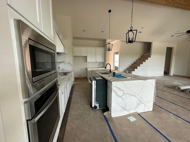 1045 Woodland Rd, Weatherford, TX 76088 - kitchen featuring appliances with stainless steel finishes, white cabinetry, a sink, a center island with sink, and decorative light fixtures