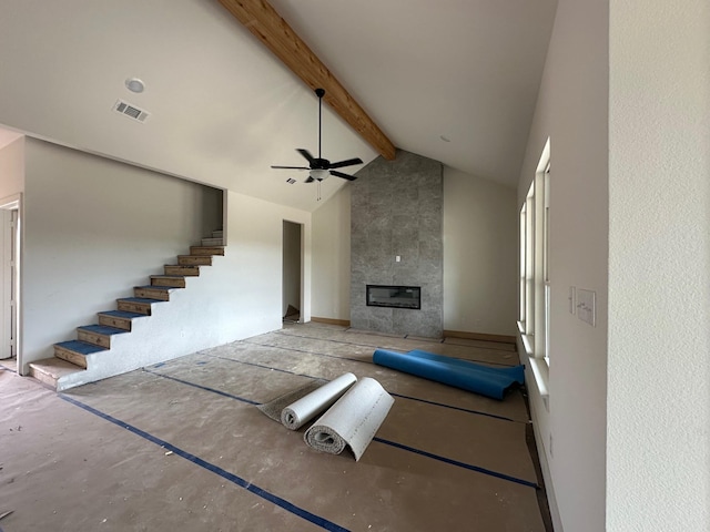1045 Woodland Rd, Weatherford, TX 76088 - unfurnished living room with a ceiling fan, beamed ceiling, stairs, a tile fireplace, and high vaulted ceiling