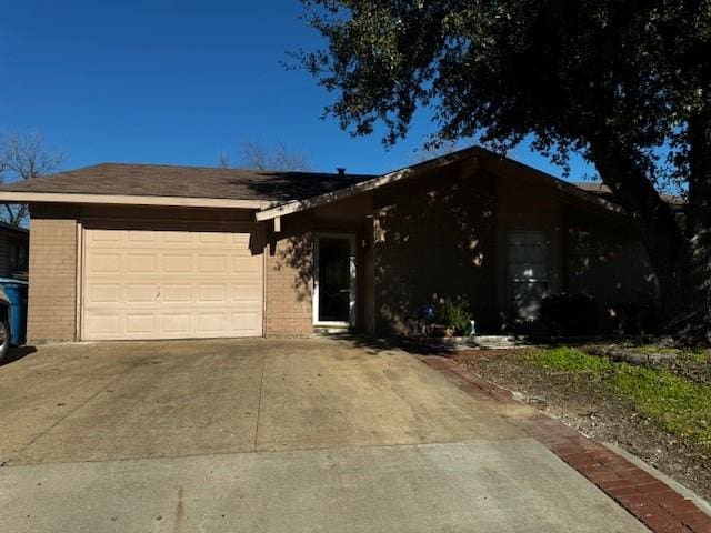 ranch-style home with concrete driveway, brick siding, and an attached garage