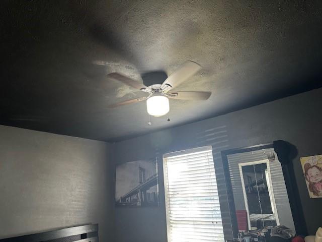 room details featuring a ceiling fan and a textured ceiling