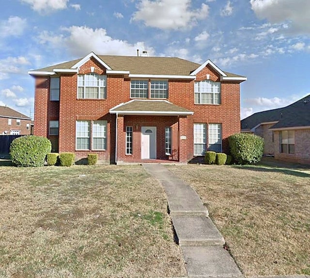 view of front of property featuring brick siding and a front lawn