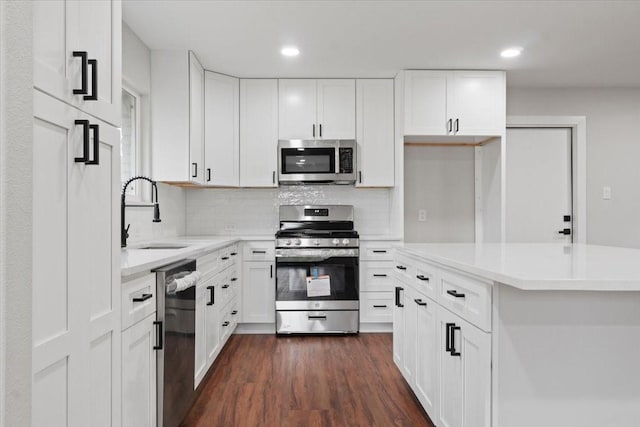 kitchen featuring stainless steel appliances, white cabinets, light countertops, and a sink