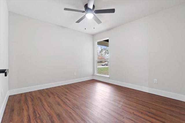 unfurnished room featuring baseboards, dark wood finished floors, and a ceiling fan