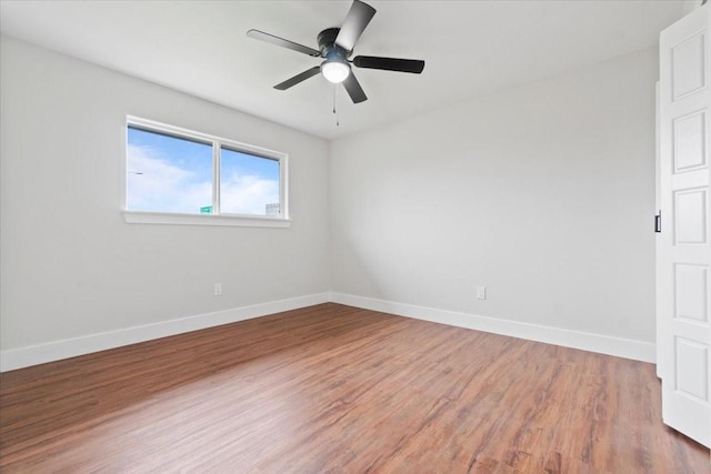 unfurnished room with wood finished floors, a ceiling fan, and baseboards