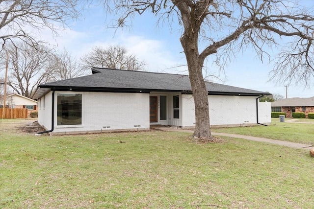 back of property featuring crawl space, a yard, and brick siding