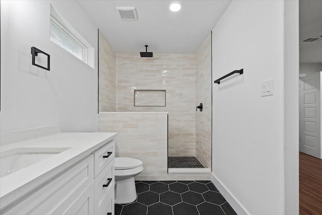 bathroom with toilet, visible vents, walk in shower, and vanity