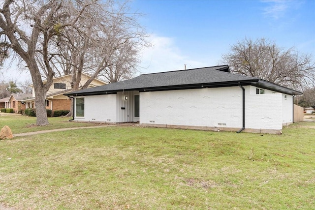 view of front of home with a front yard, crawl space, brick siding, and roof with shingles