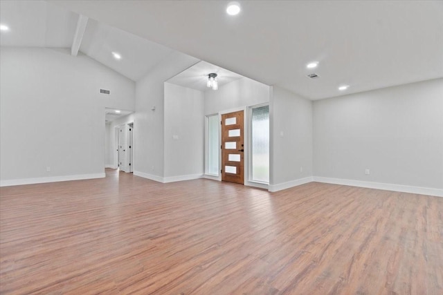 unfurnished living room with visible vents, baseboards, lofted ceiling with beams, light wood-style flooring, and recessed lighting