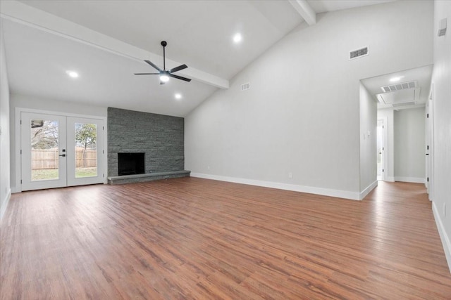 unfurnished living room with a fireplace, visible vents, baseboards, light wood-type flooring, and beamed ceiling