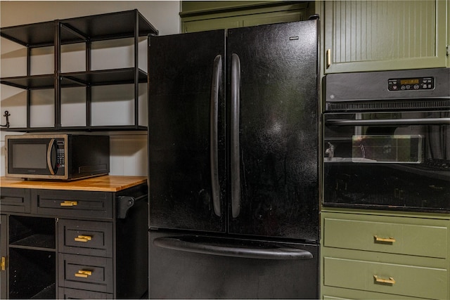 kitchen featuring black appliances, wood counters, and green cabinetry