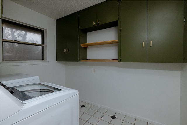 laundry room featuring washing machine and dryer, cabinet space, a textured ceiling, and baseboards