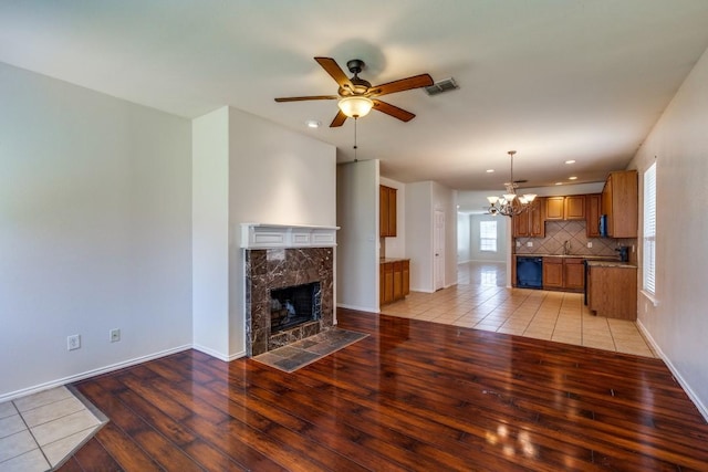 8860 Noontide Dr, Fort Worth, TX 76179 - unfurnished living room featuring light wood-style floors, a chandelier, ceiling fan, a high end fireplace, and recessed lighting