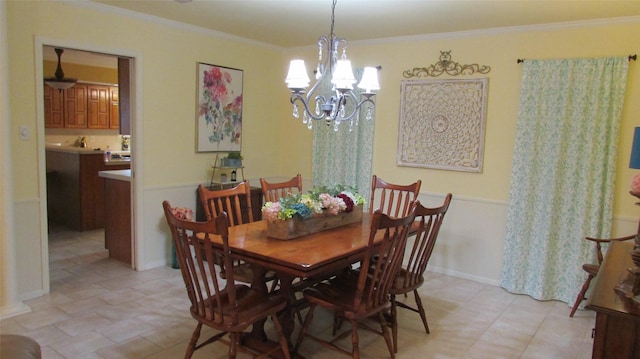 dining space with a notable chandelier, baseboards, and crown molding