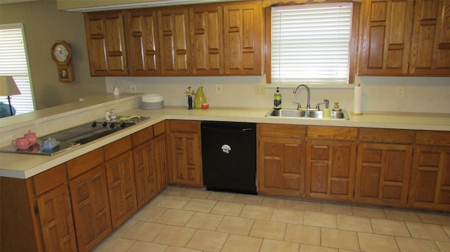 kitchen with a peninsula, black dishwasher, light countertops, and a sink