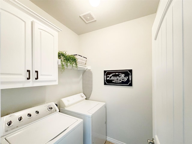 washroom with visible vents, cabinet space, and separate washer and dryer