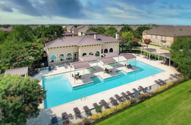 pool with a patio area and fence