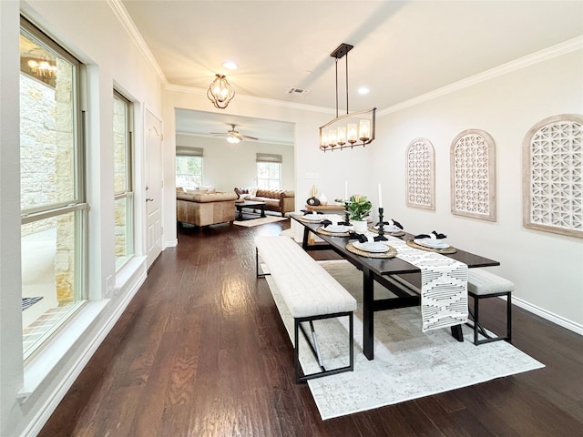 dining space with dark wood-type flooring, crown molding, and baseboards