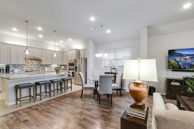 living area featuring recessed lighting, dark wood-style flooring, and visible vents