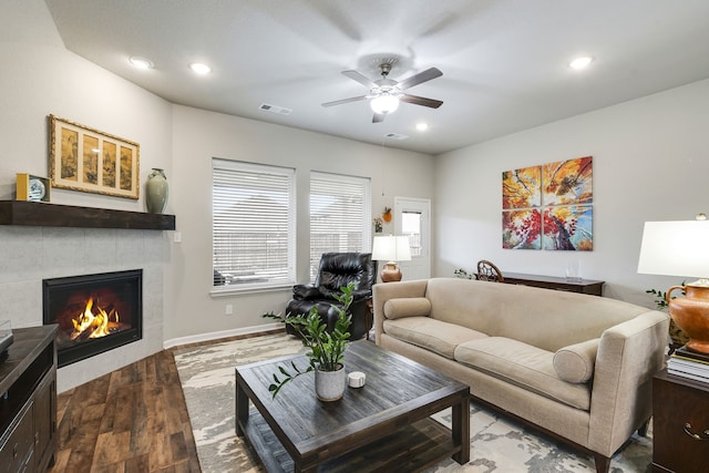 living area featuring recessed lighting, wood finished floors, visible vents, baseboards, and a tiled fireplace