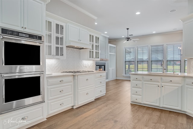 kitchen with glass insert cabinets, white cabinetry, appliances with stainless steel finishes, and light countertops