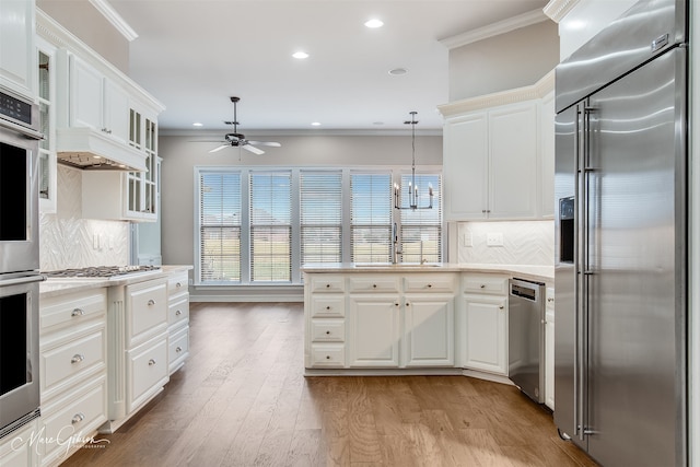 kitchen featuring glass insert cabinets, appliances with stainless steel finishes, light countertops, and white cabinets