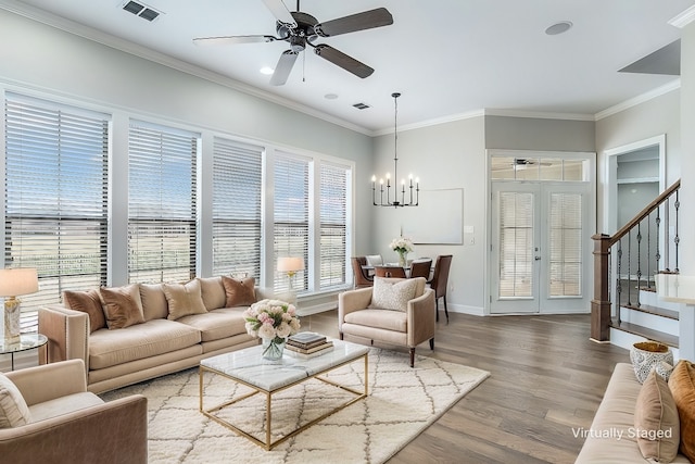 living room with visible vents, crown molding, stairway, and wood finished floors