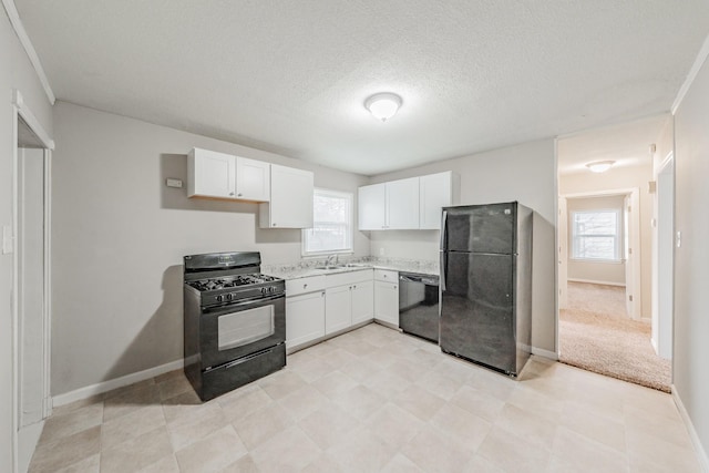 kitchen featuring black appliances, plenty of natural light, light countertops, and white cabinetry