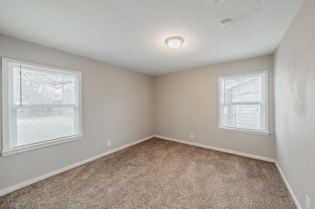 unfurnished room with baseboards, a wealth of natural light, and carpet flooring