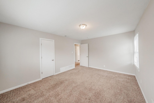 unfurnished room featuring carpet and baseboards