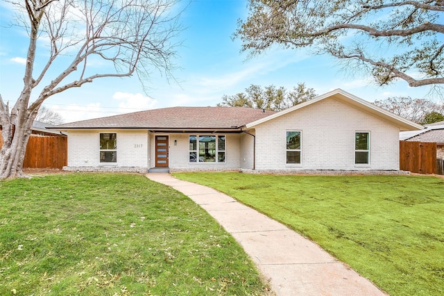 single story home with brick siding, a front yard, and fence