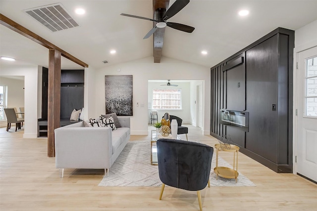 living room featuring vaulted ceiling with beams, heating unit, recessed lighting, visible vents, and light wood-style flooring