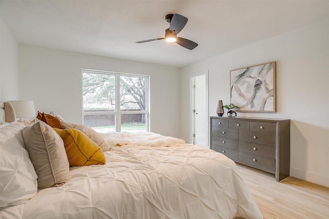 bedroom featuring light wood-type flooring, a ceiling fan, and baseboards