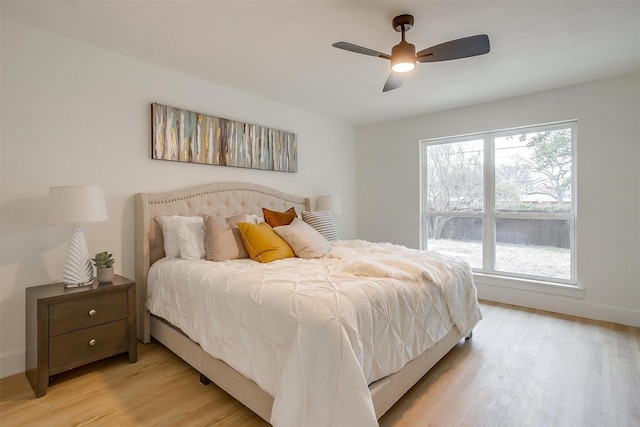 bedroom featuring light wood-style floors, baseboards, and a ceiling fan