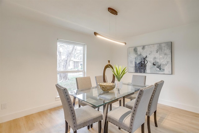 dining room with baseboards and light wood finished floors