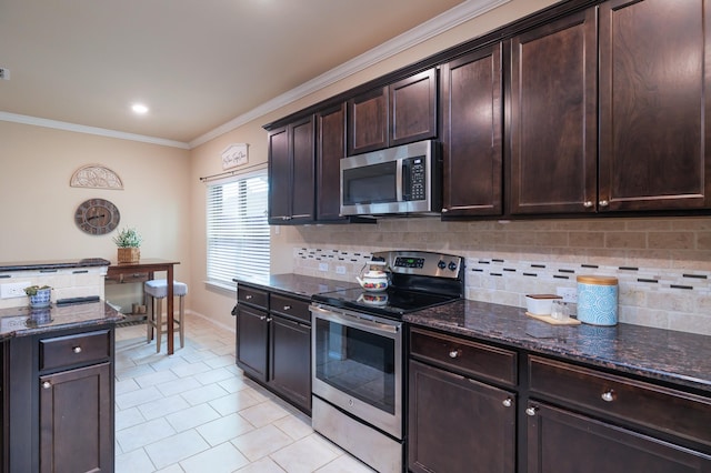 kitchen featuring stainless steel appliances, dark brown cabinets, ornamental molding, dark stone counters, and tasteful backsplash