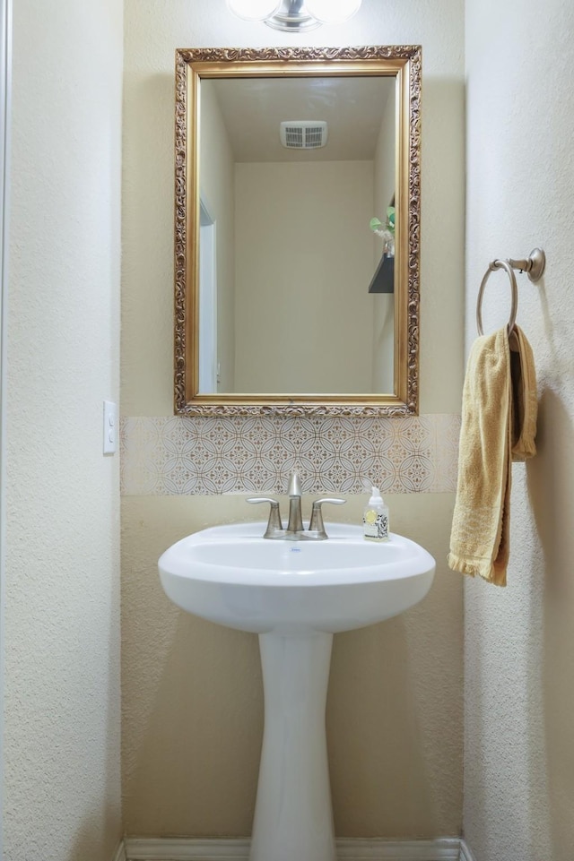 bathroom featuring visible vents and decorative backsplash