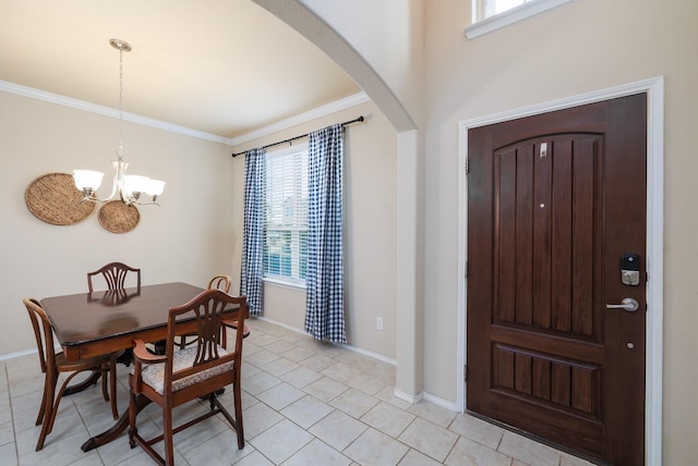 dining area featuring ornamental molding, arched walkways, a notable chandelier, and baseboards