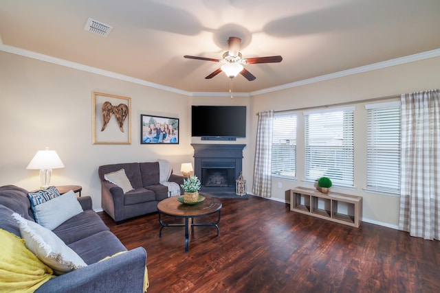 living room with dark wood-style floors, visible vents, a fireplace with raised hearth, and ornamental molding