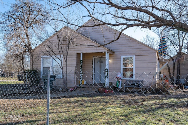 bungalow-style home with fence and a front lawn