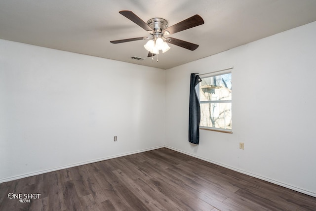 empty room with dark wood-type flooring, visible vents, baseboards, and a ceiling fan