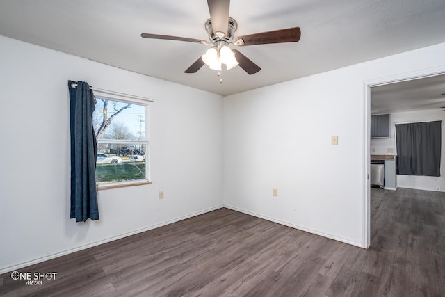 unfurnished room with baseboards, a ceiling fan, and dark wood-style flooring